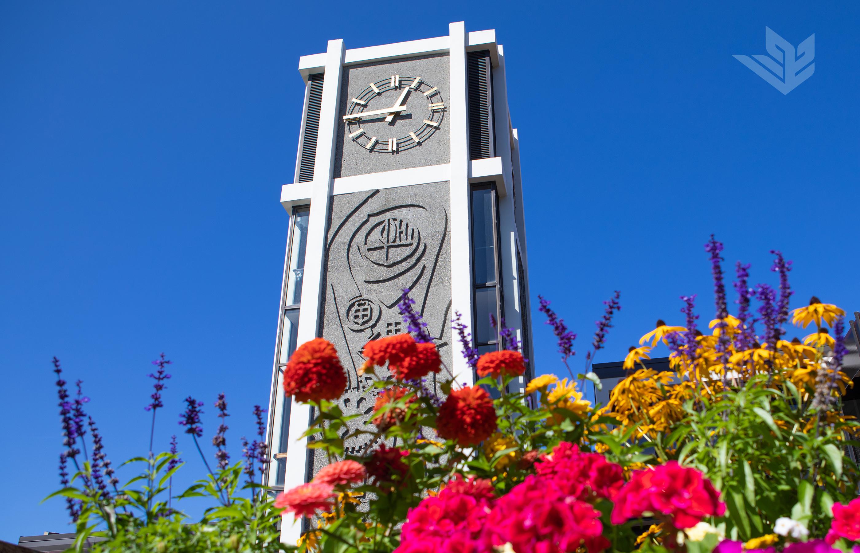 标志性的德马雷大厅钟楼，在夏日鲜花的背后，在万里无云的蓝天前